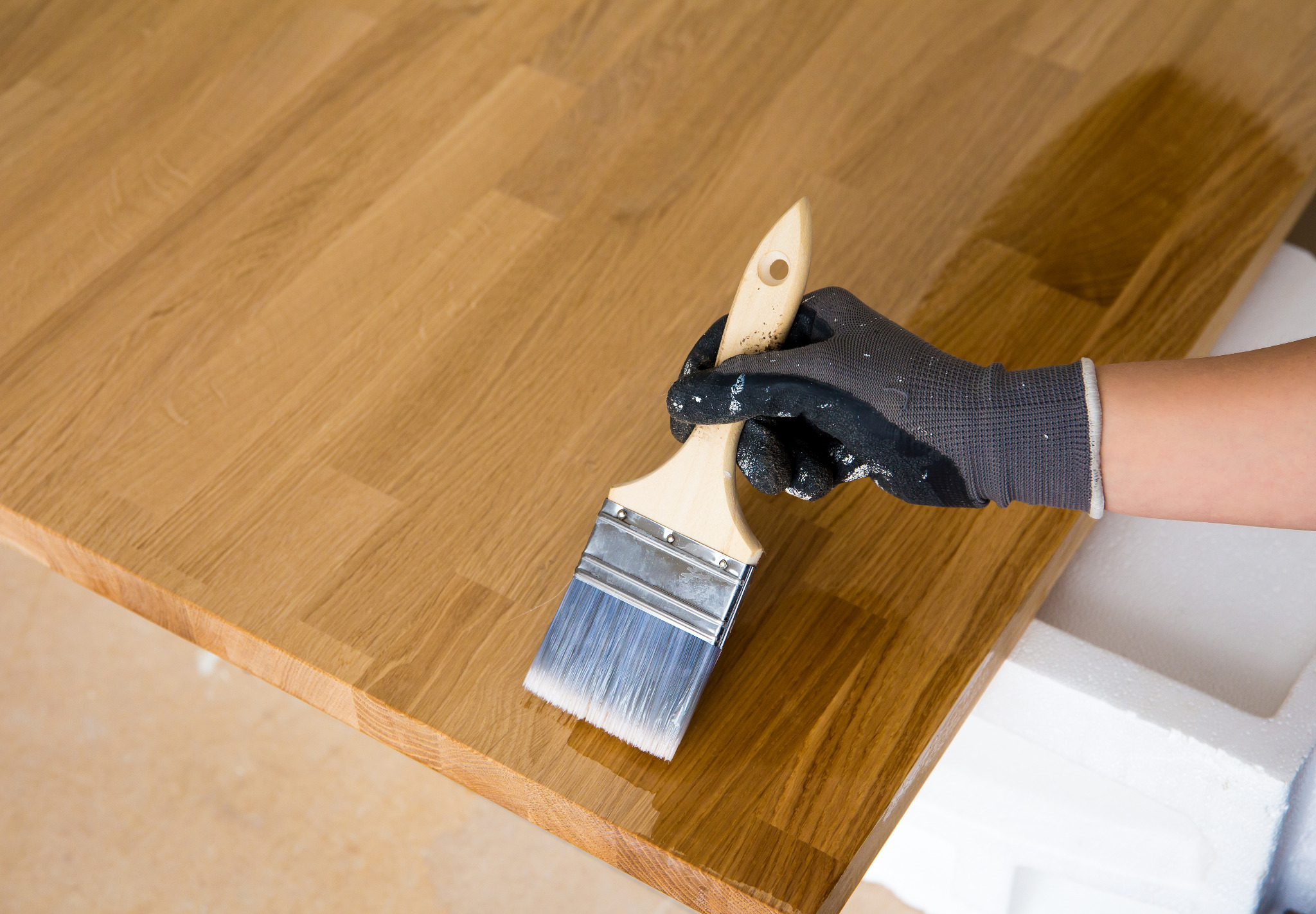 Hardwood Floor Sanding in Surbiton — oak solid-wood worktop being brushed with clear oil, showing grain pop; part of our oak hardwood floor & worktop refinishing service.