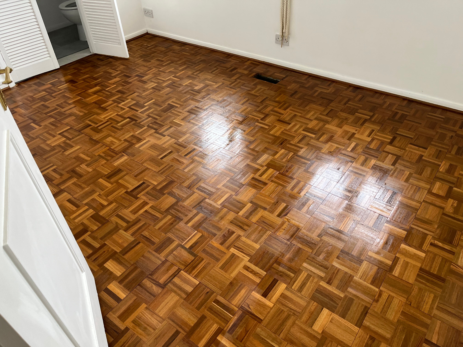 Wood Floor Sanding in Surbiton on a finished oak mosaic parquet bedroom floor, showing a smooth, glossy timber surface after professional restoration.