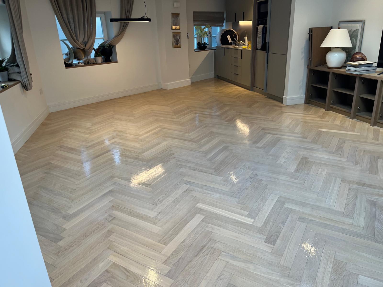 Parquet Floor Sanding in Surbiton showing a finished light oak herringbone parquet floor with a smooth polished surface and elegant natural tone