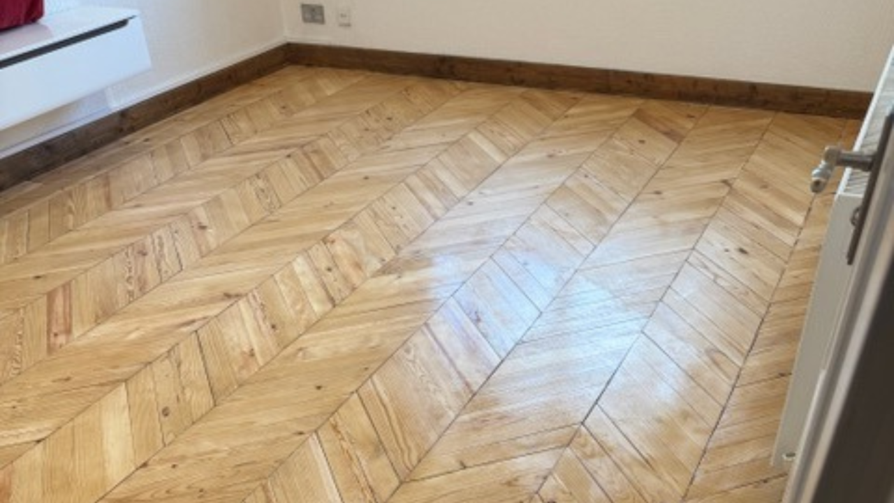 Parquet Floor Sanding in Surbiton showing a light oak chevron parquet floor with a smooth finish and clean geometric pattern