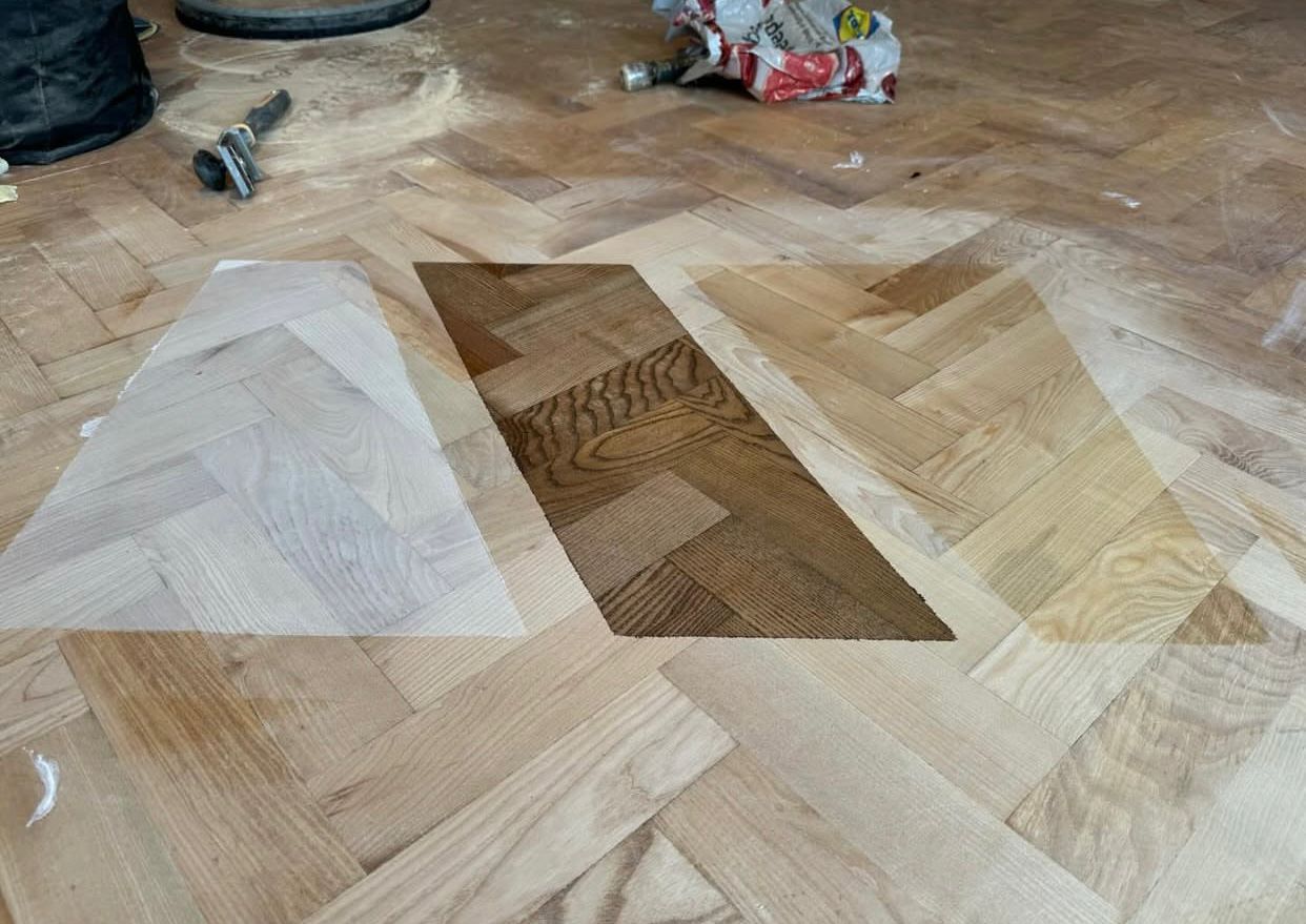 Parquet Floor Sanding in Surbiton showing oak herringbone parquet floor with stain colour samples during professional restoration